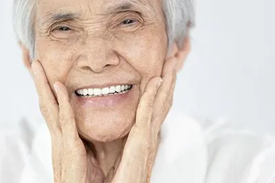 woman loving the look of her smile after getting all-on-4 dental implants