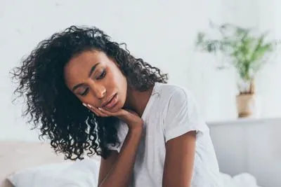 woman holding her mouth experiencing tooth pain