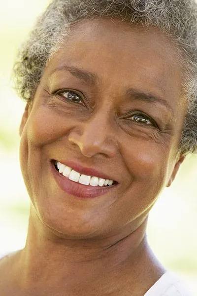 woman showing off her freshly restored smile thanks to dental crowns
